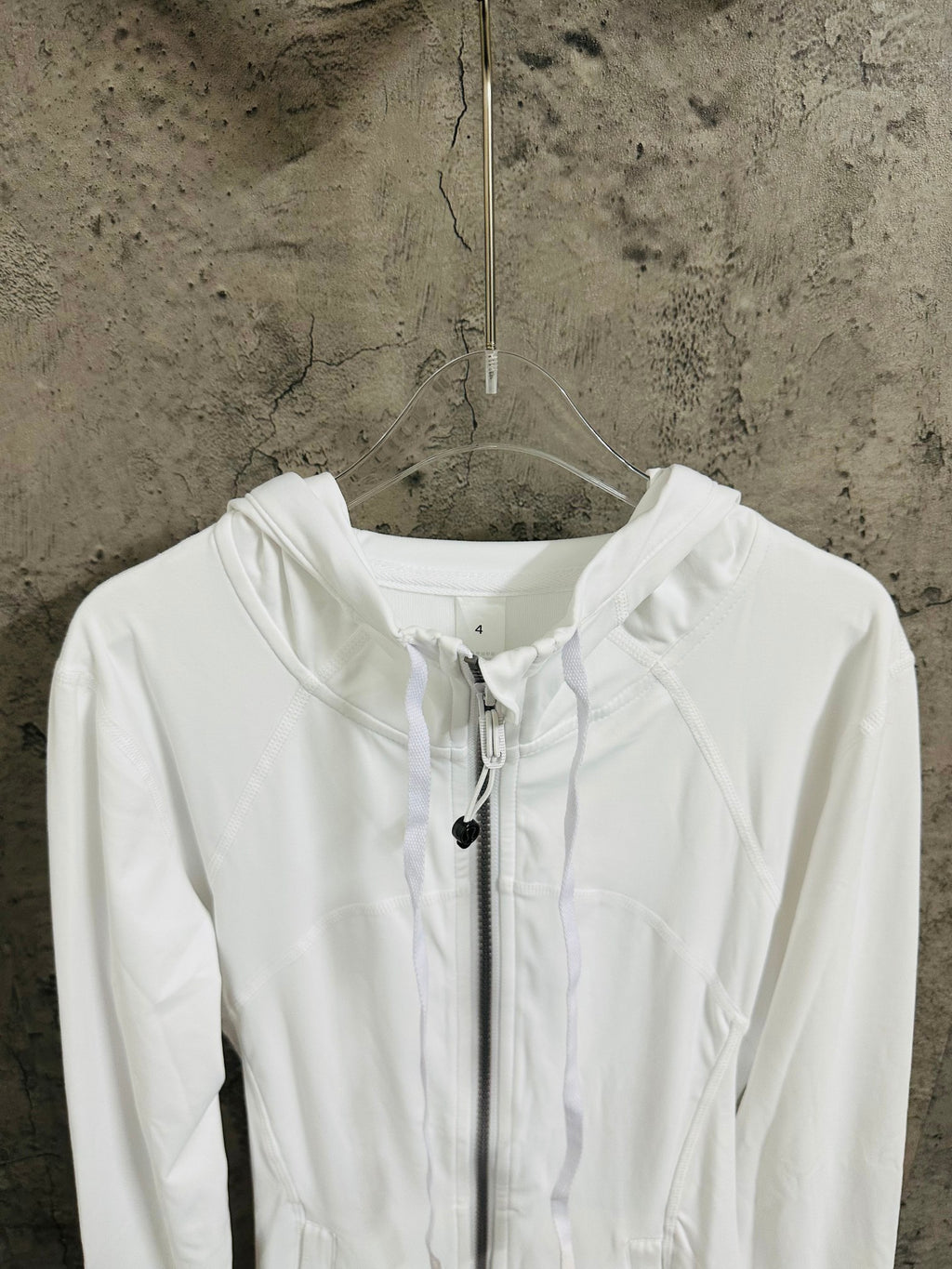 White hooded jacket front view, drawstring hood and zip closure