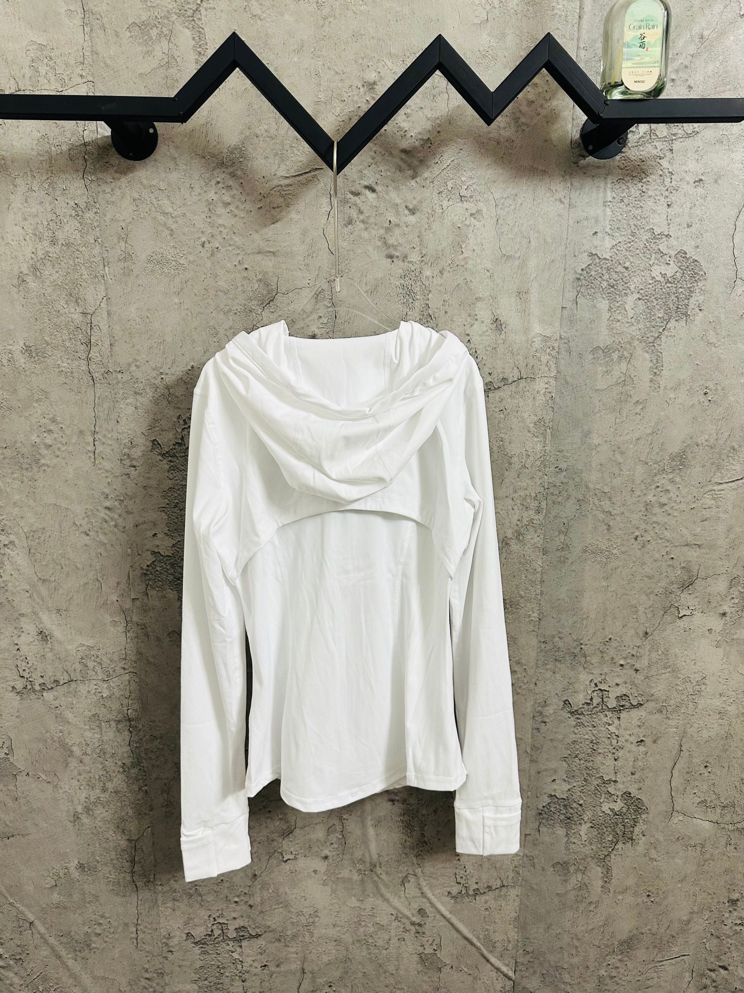 White hooded jacket worn with hood down, full front zip and long sleeves