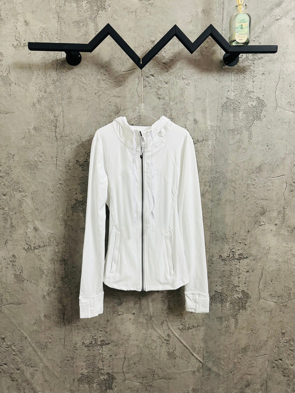 White zip-up hooded jacket with long sleeves and front pockets