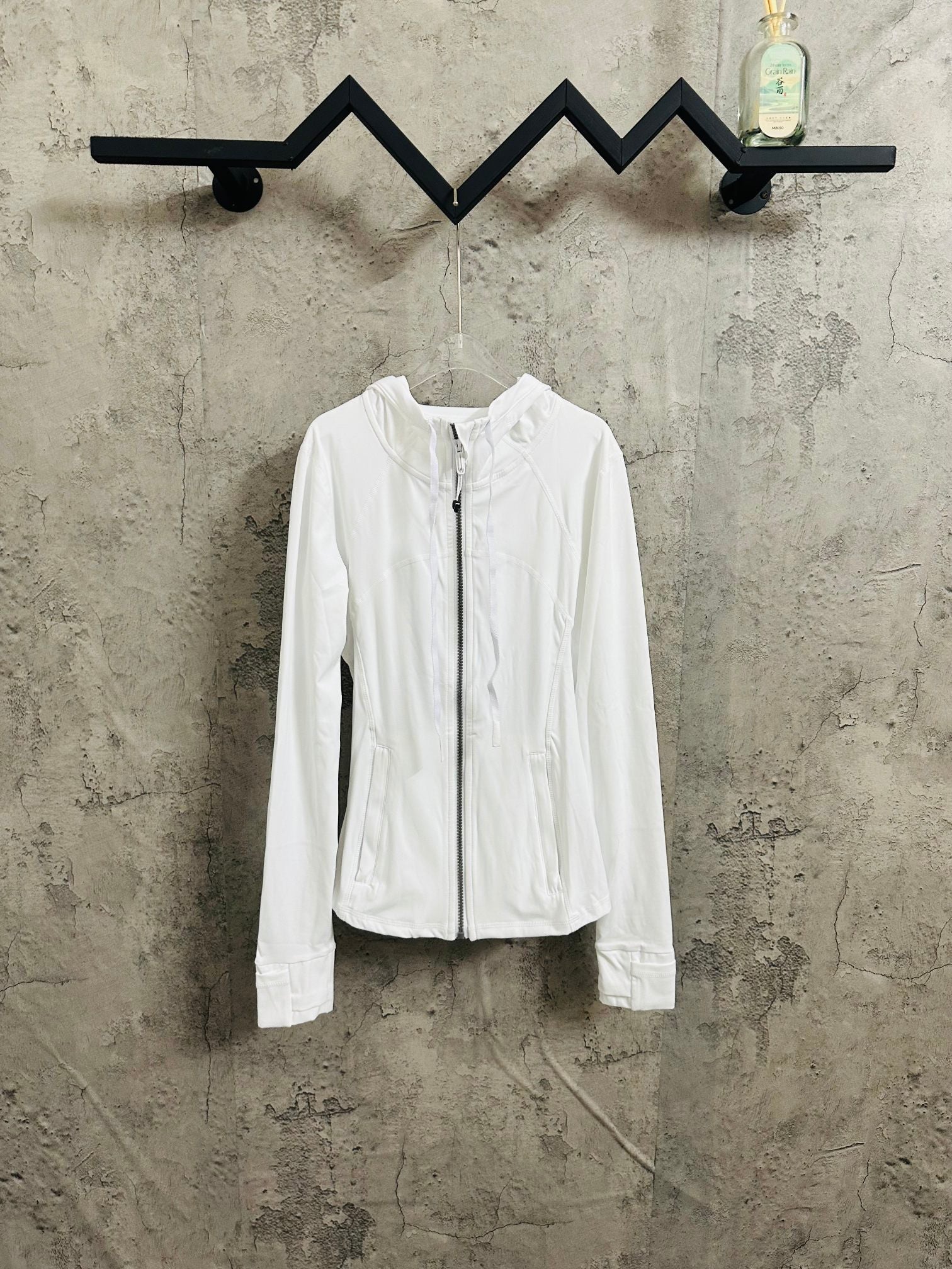 White zip-up hooded jacket with long sleeves and front pockets