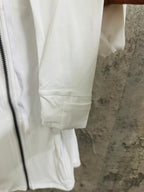 White jacket close-up of sleeve cuff and drawstring waist hem
