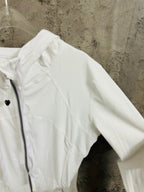 White jacket sleeve and shoulder close-up with zip front and hood edge
