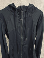 Dark hooded zip jacket with stand collar and zipper pull