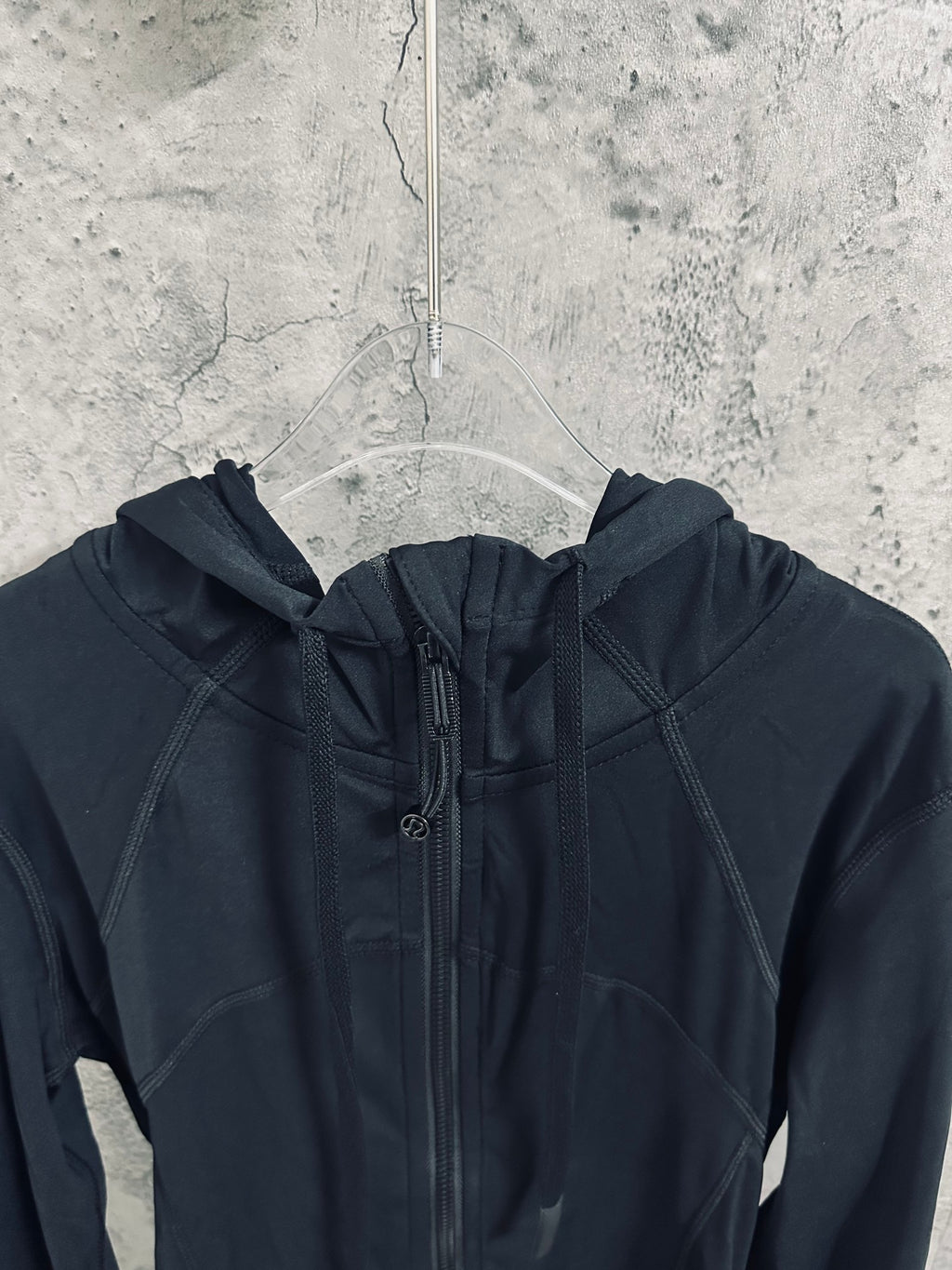 Dark hooded jacket with drawstring hood and full-length zipper