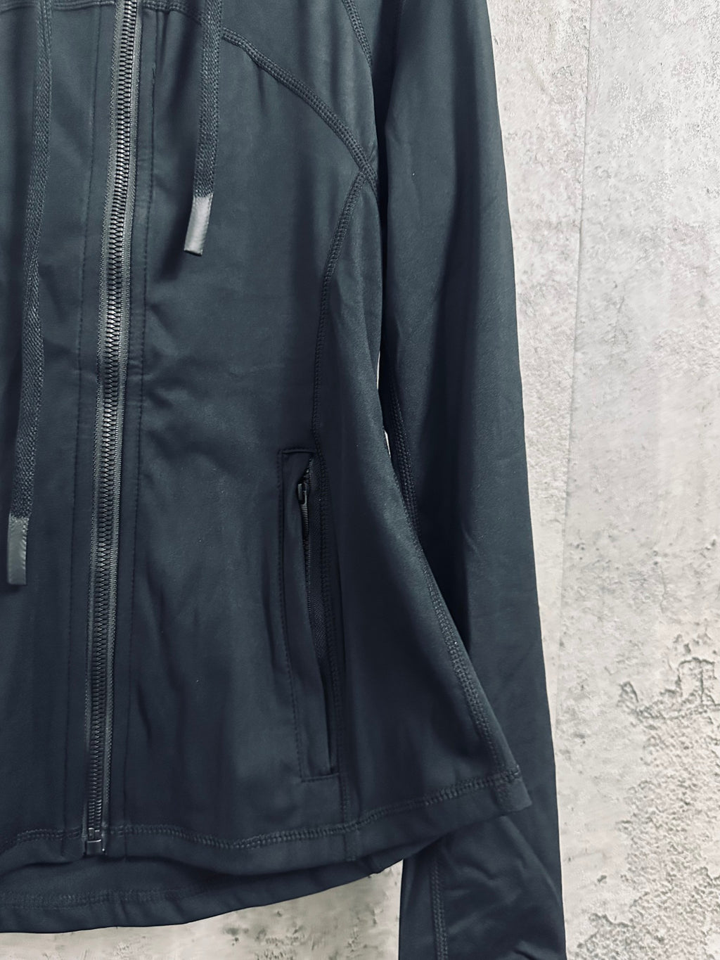 Dark zip jacket with side pocket, seam stitching, and long sleeves