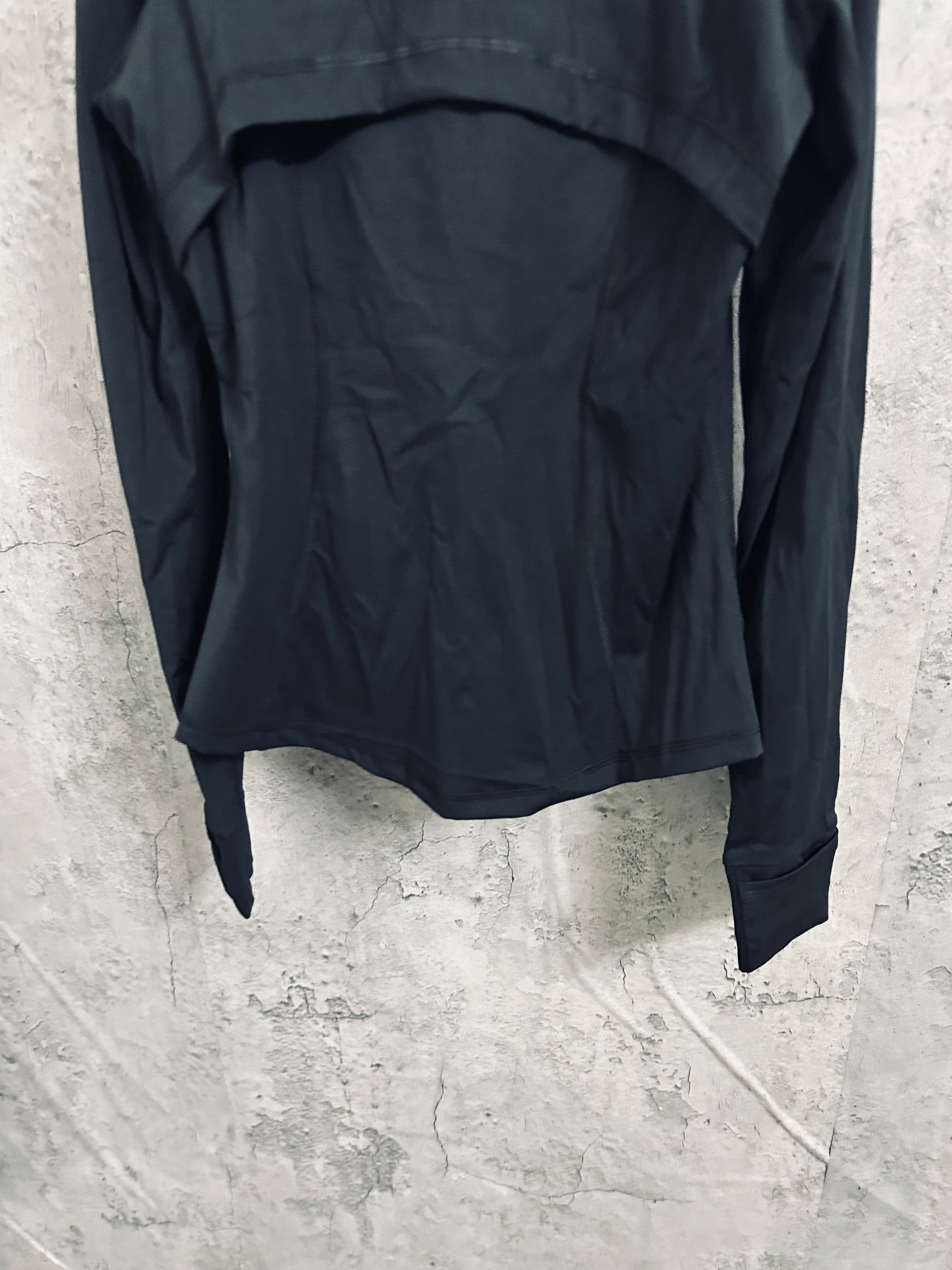 Dark hooded jacket back view with curved hem and long sleeves