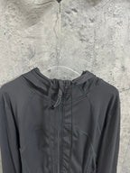 Dark hooded jacket close-up with center zipper and drawcord hood