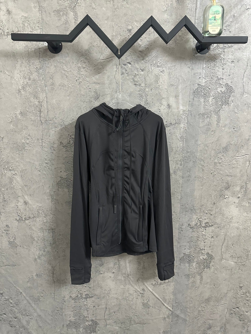 Dark hooded zip-up jacket with drawstring hem and front pockets