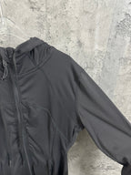 Dark hooded jacket sleeve and shoulder with curved stitched seam lines