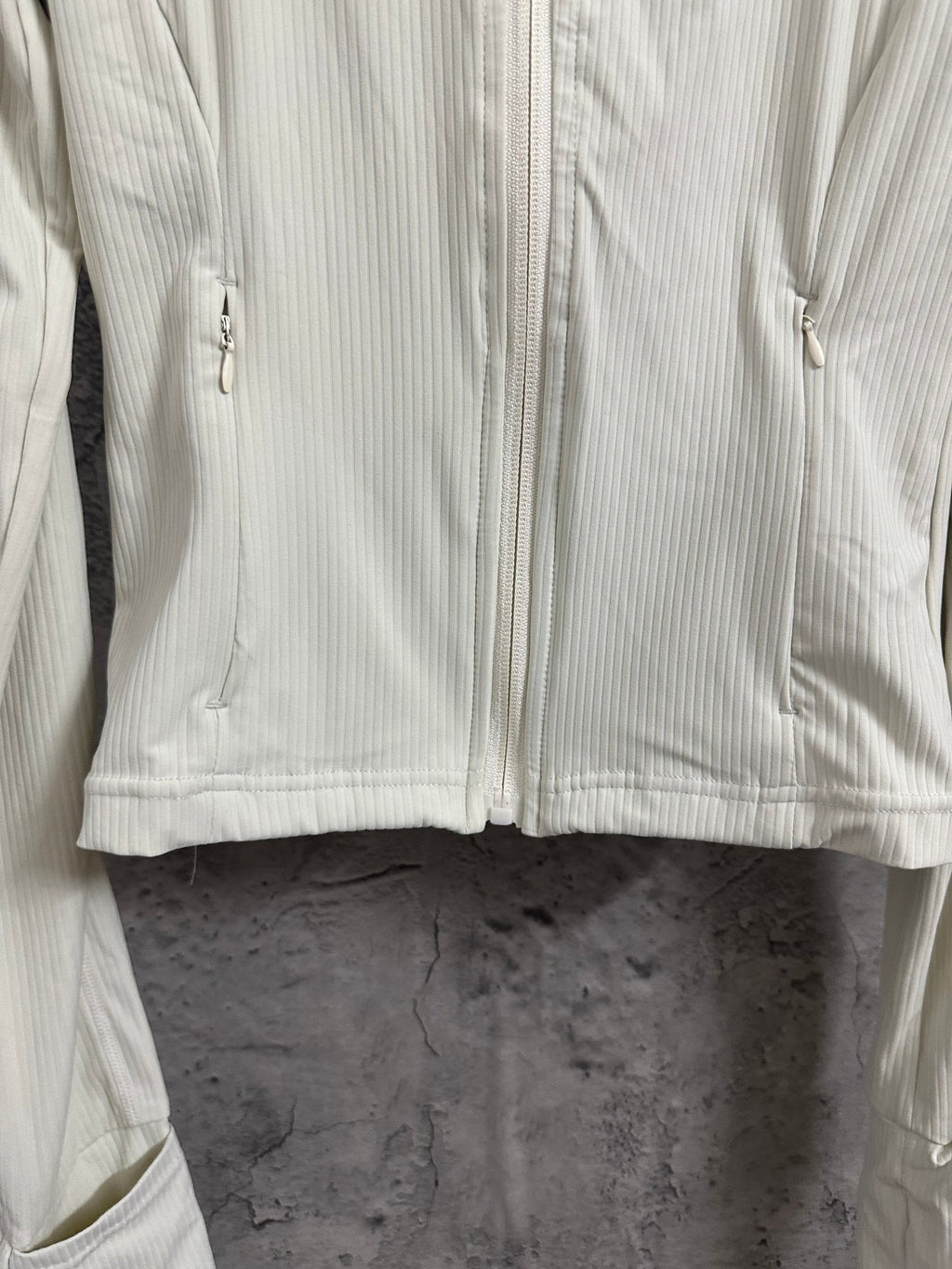 Light cream ribbed jacket front with full zipper and stitched curved yoke seam