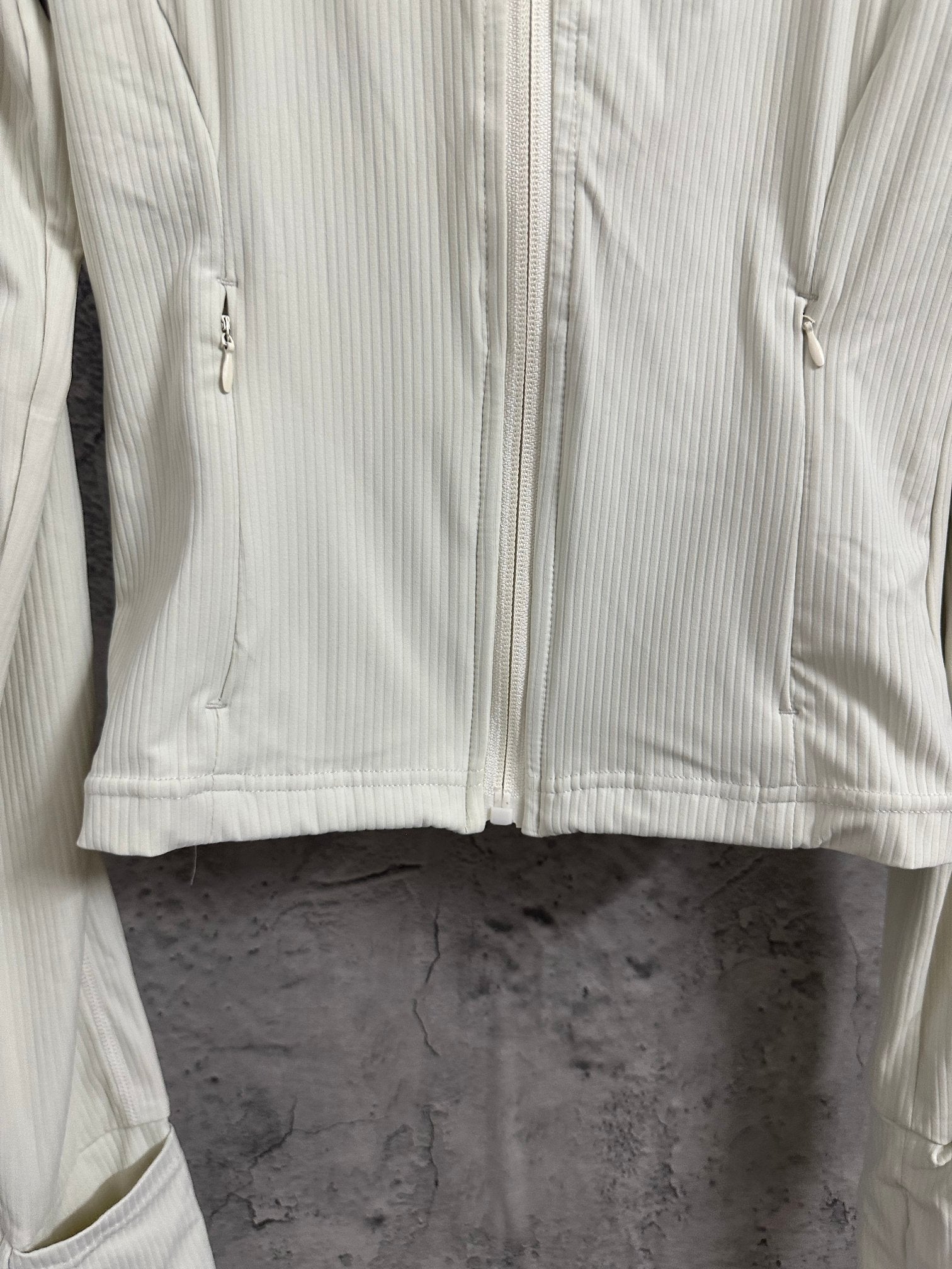 Light cream ribbed jacket front with full zipper and stitched curved yoke seam