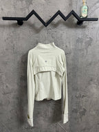 Light cream ribbed high-neck jacket with curved yoke seam and small circular chest logo