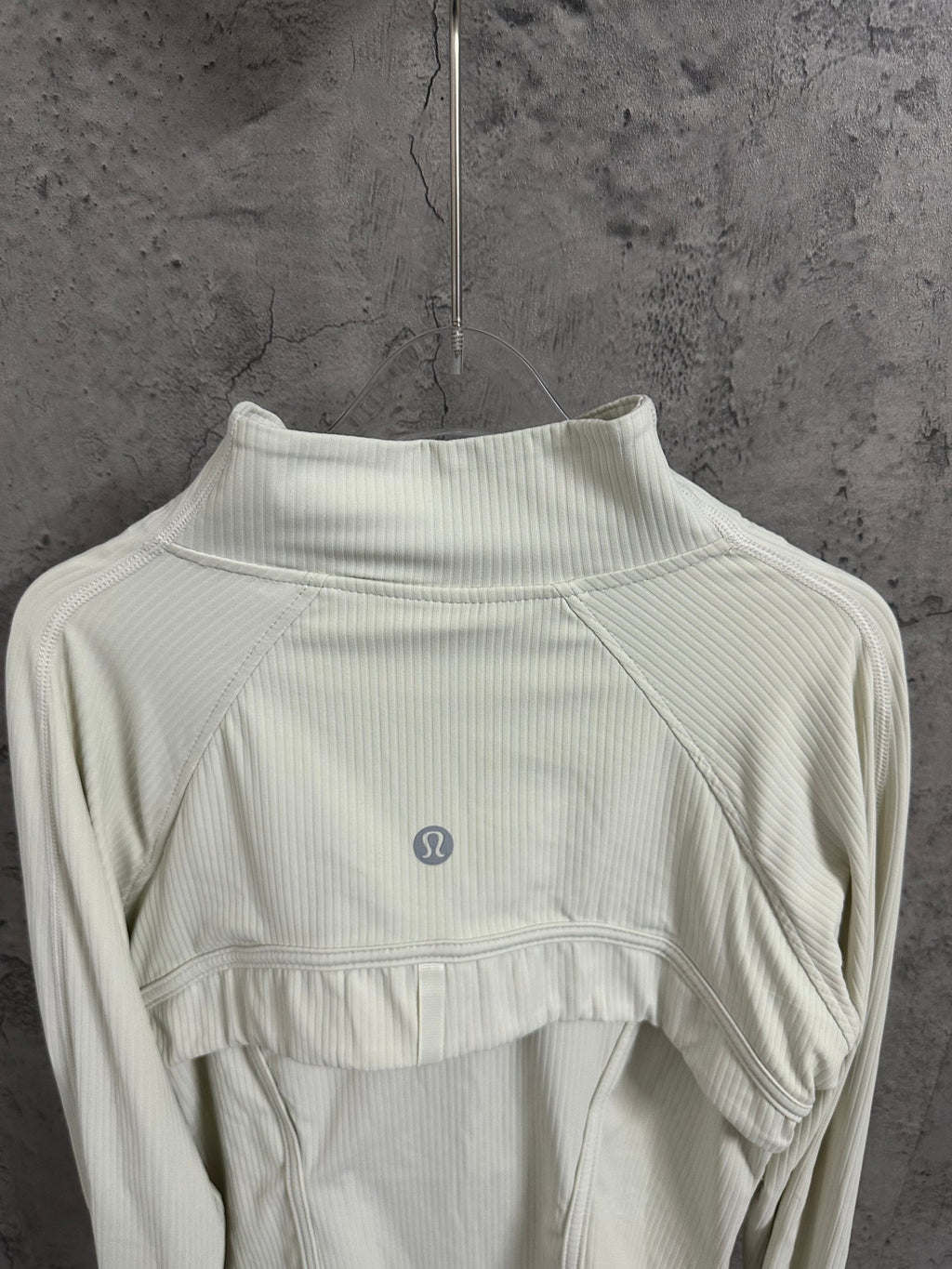 Light cream ribbed high-neck jacket with curved yoke seam and small chest logo