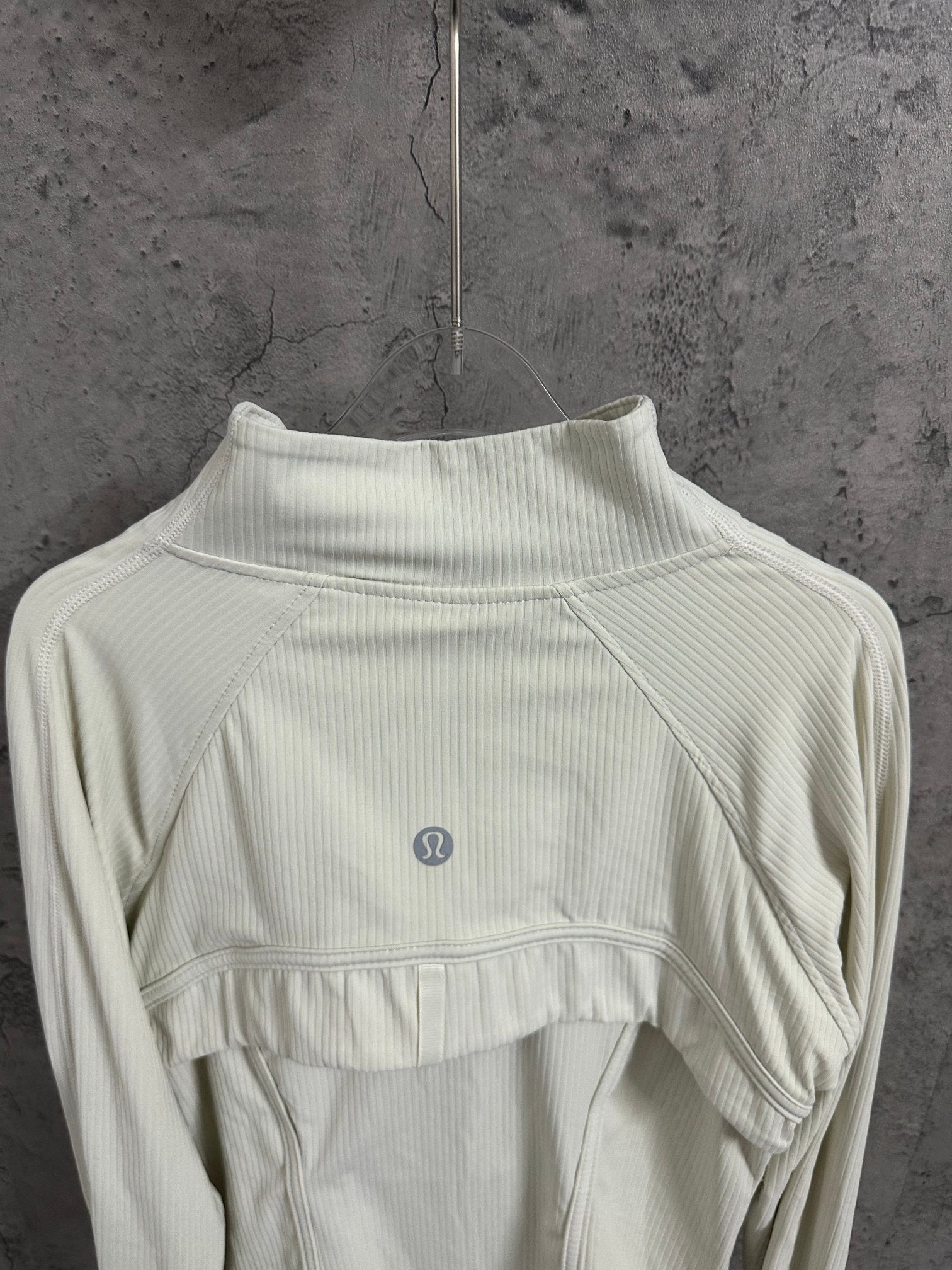 Light cream ribbed high-neck jacket with curved yoke seam and small chest logo