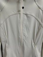 Light cream ribbed jacket detail with full zipper and curved chest seam