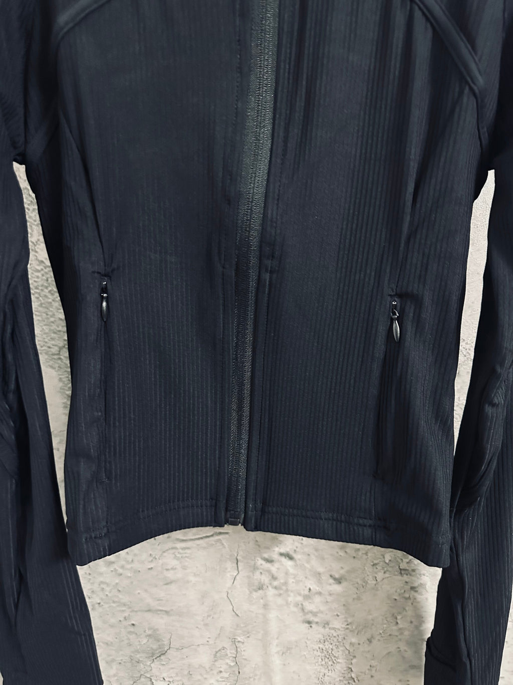Dark zip-front jacket with two side zippers and curved chest seam