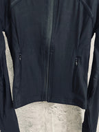 Dark zip-front jacket with two side zippers and curved chest seam