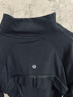 Dark stand-collar zip jacket with chest emblem and short front vent