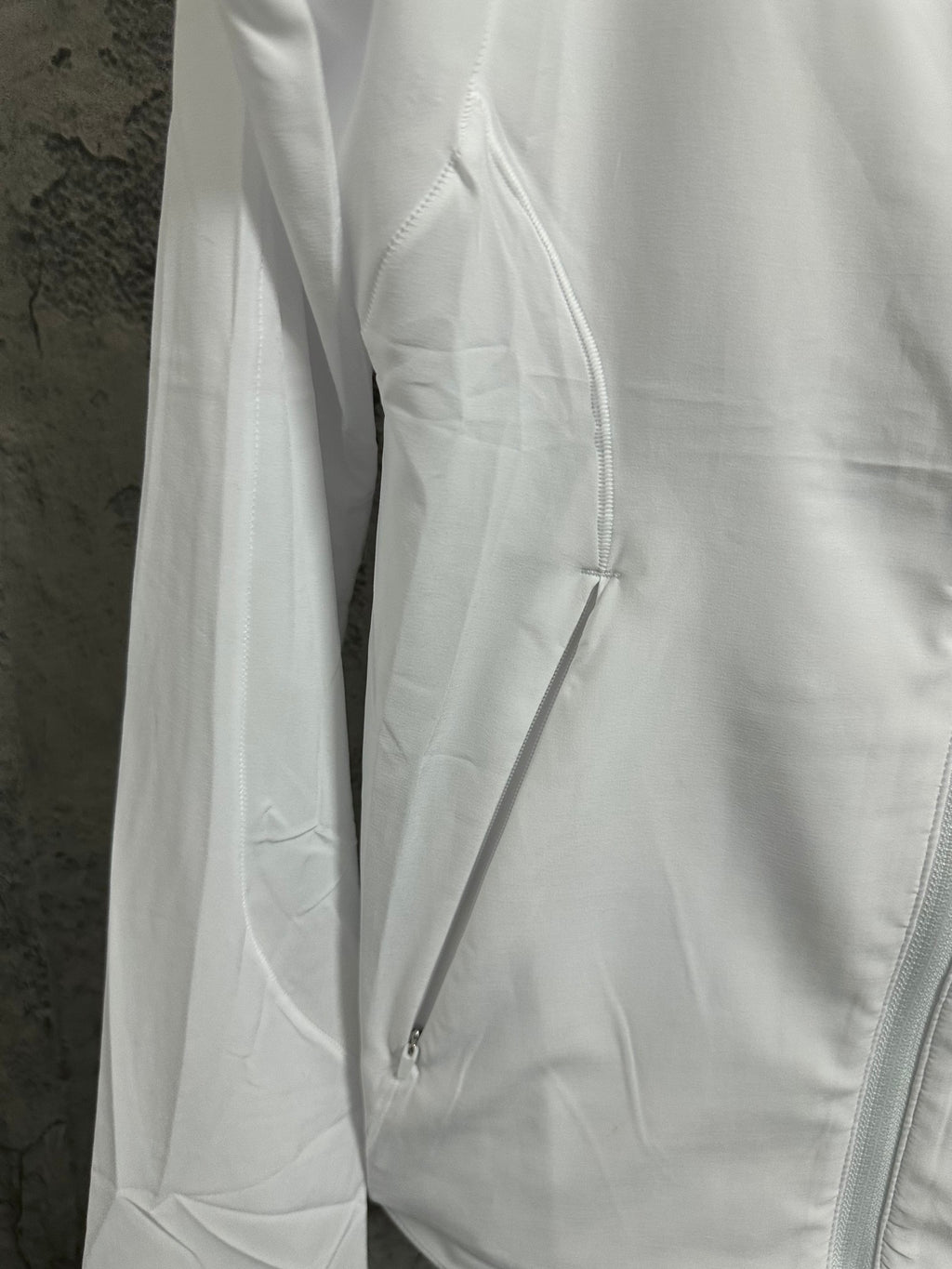 White jacket side detail with drawcord and zipper seam