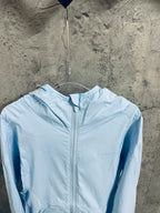 Light blue hooded windbreaker jacket with front zipper and ribbed hood