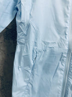 Light blue windbreaker jacket front pocket with zipper detail