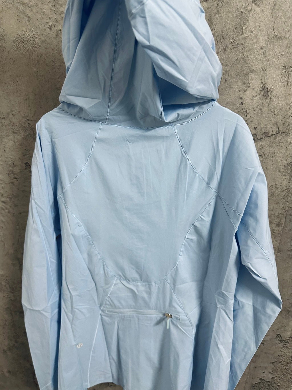 Light blue hooded windbreaker jacket, back view with drawstring hem