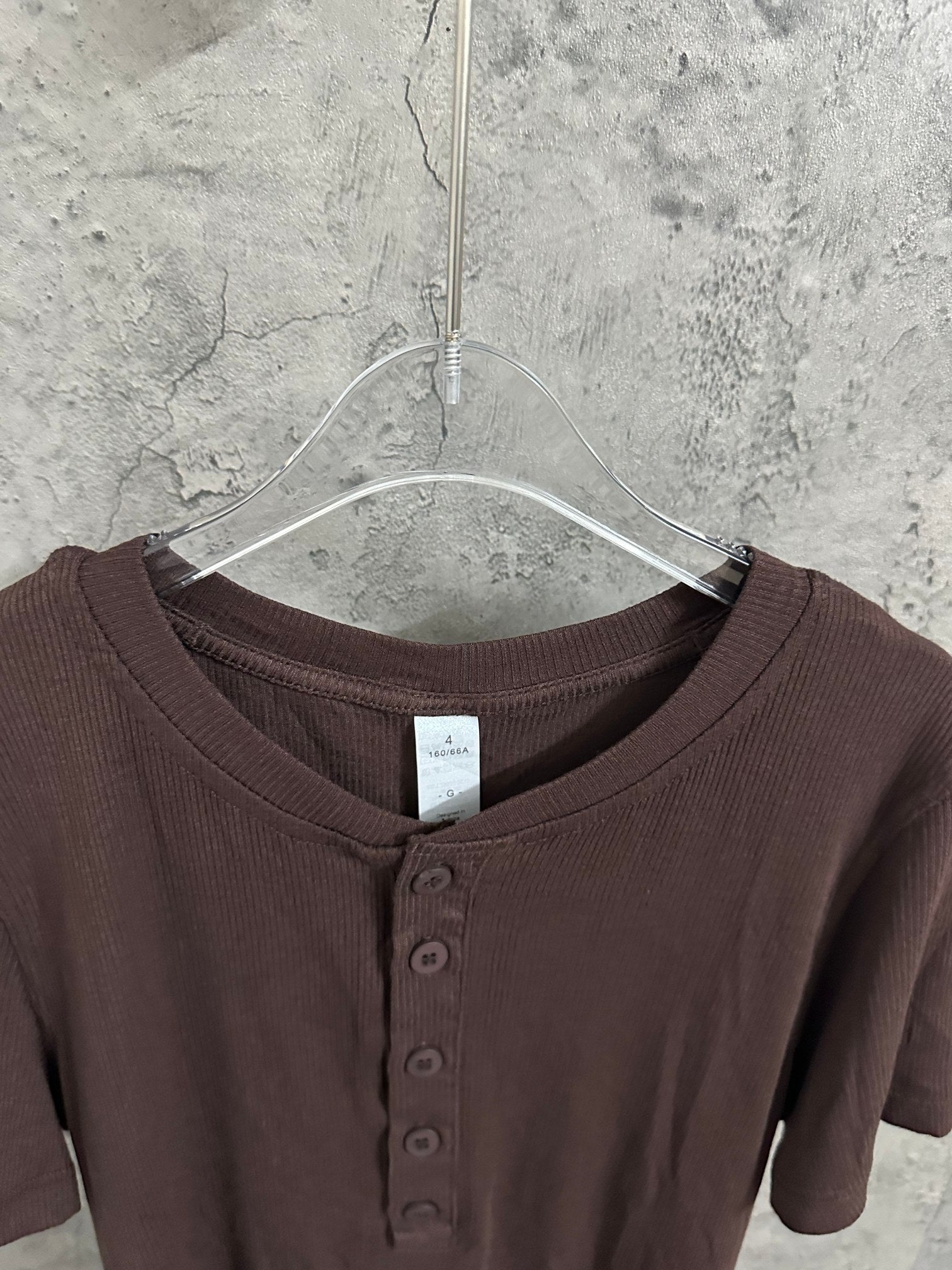Brown henley T-shirt neckline with three-button placket and ribbed collar