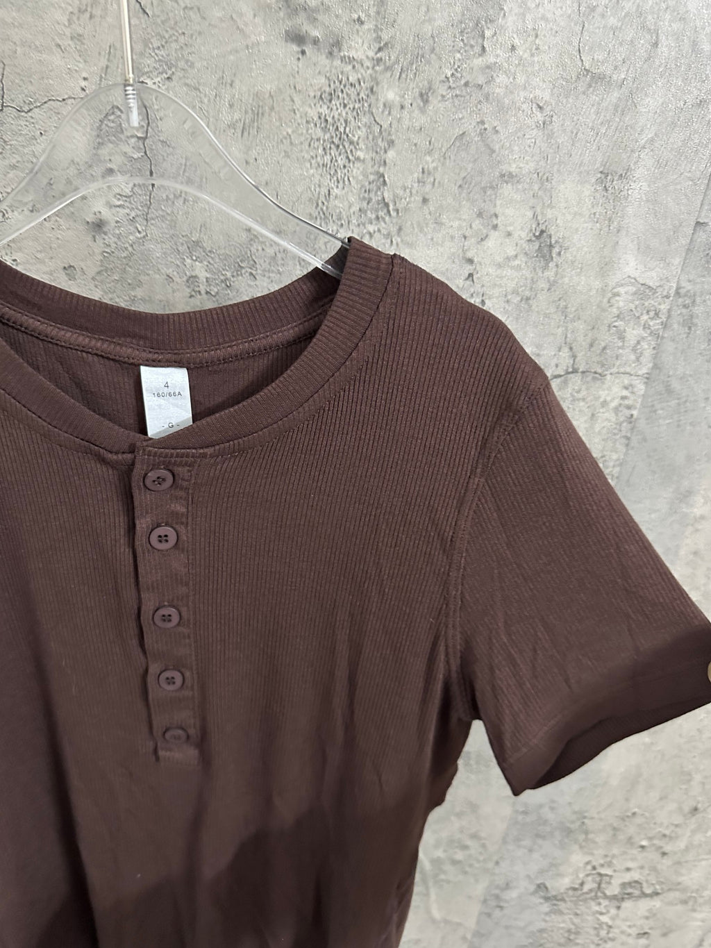 Brown henley T-shirt close-up with round crew neck and button placket