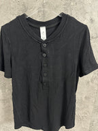 Short-sleeve henley shirt in dark knit fabric with V-neck opening and button placket.