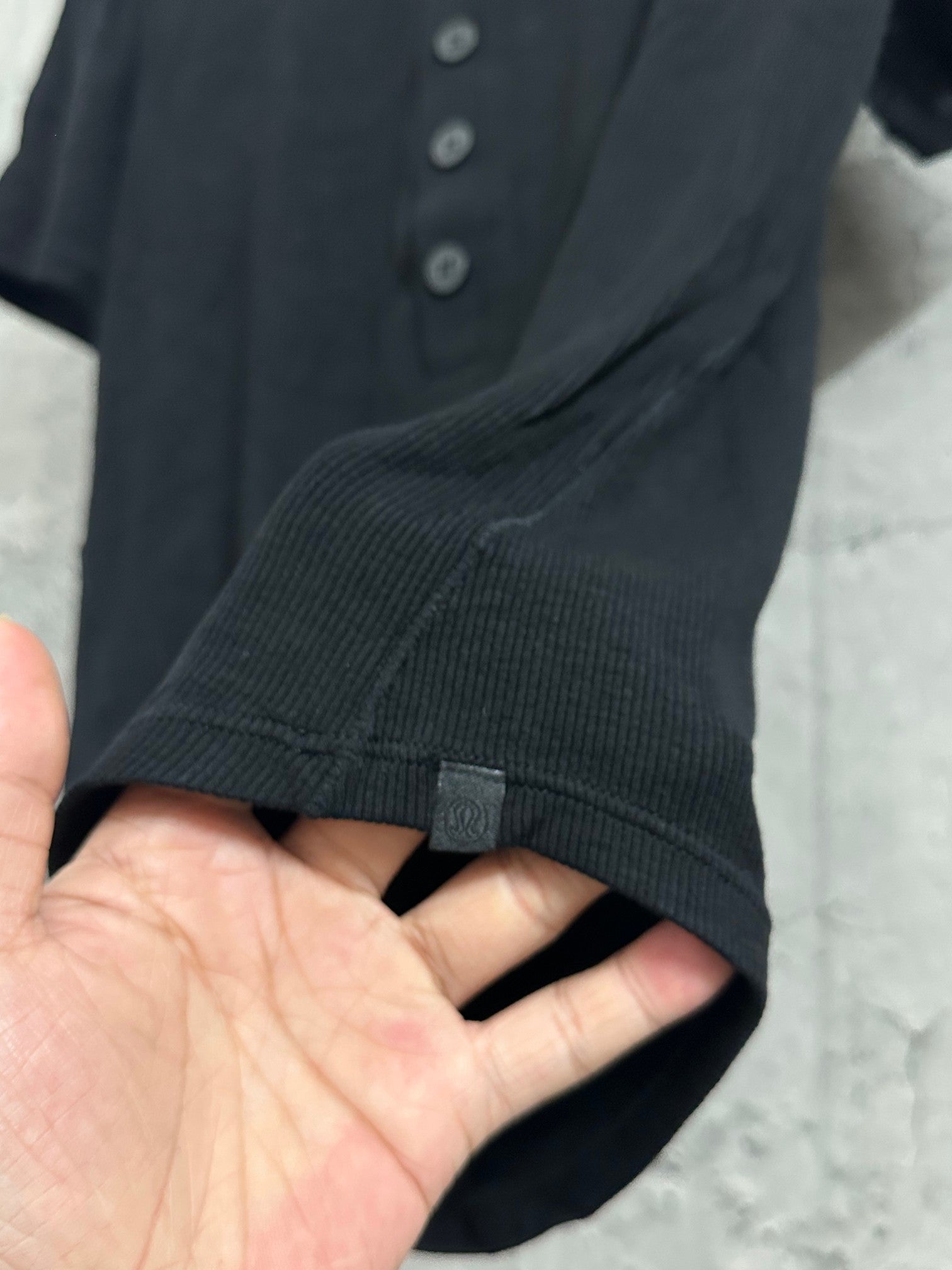 Short-sleeve henley shirt ribbed sleeve hem in dark knit fabric.