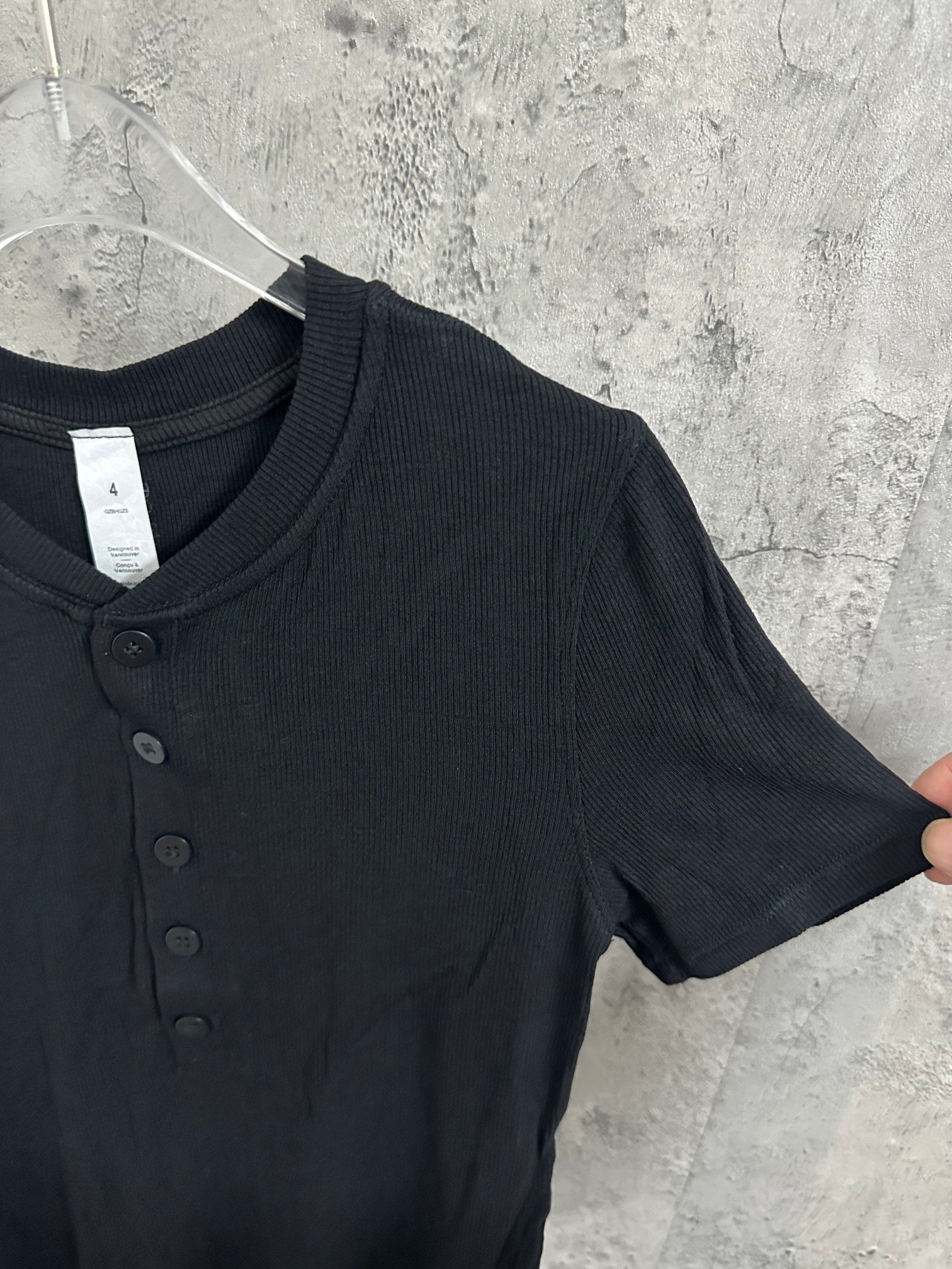 Short-sleeve henley shirt shoulder and sleeve in dark knit with ribbed crew collar.