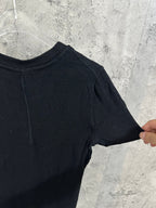 Side view of short-sleeve henley shirt in dark knit fabric with ribbed texture.