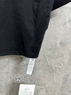 Women’s dark athletic crop top detail view of side seam and hanging tag