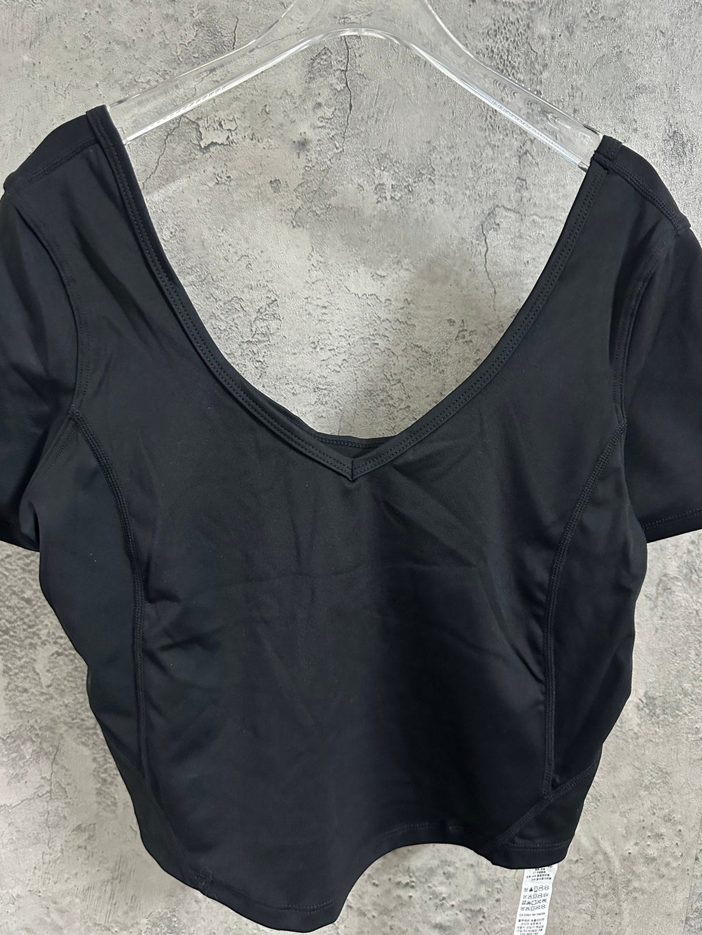 Black V-neck cropped top with short sleeves, close-up on neckline