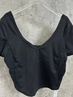 Black V-neck cropped top with short sleeves, close-up on neckline