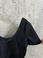 Black cropped top with V-neck and short sleeves, side view