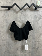 Black V-neck cropped top with short sleeves and hanging product tags