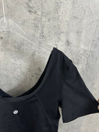 Black V-neck cropped top with short sleeves, angled view
