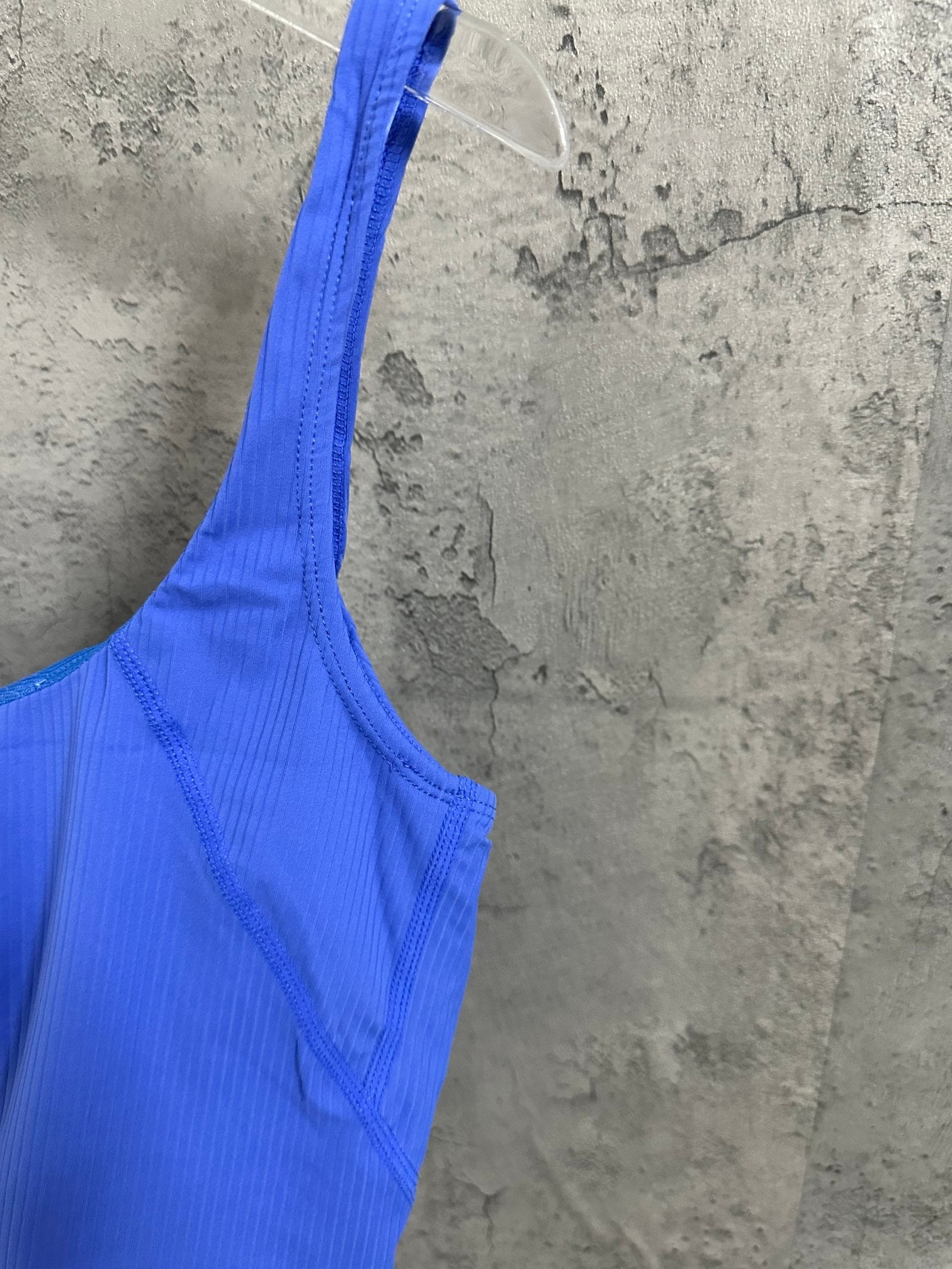 Blue ribbed tank top detail view, scoop neckline and narrow shoulder strap