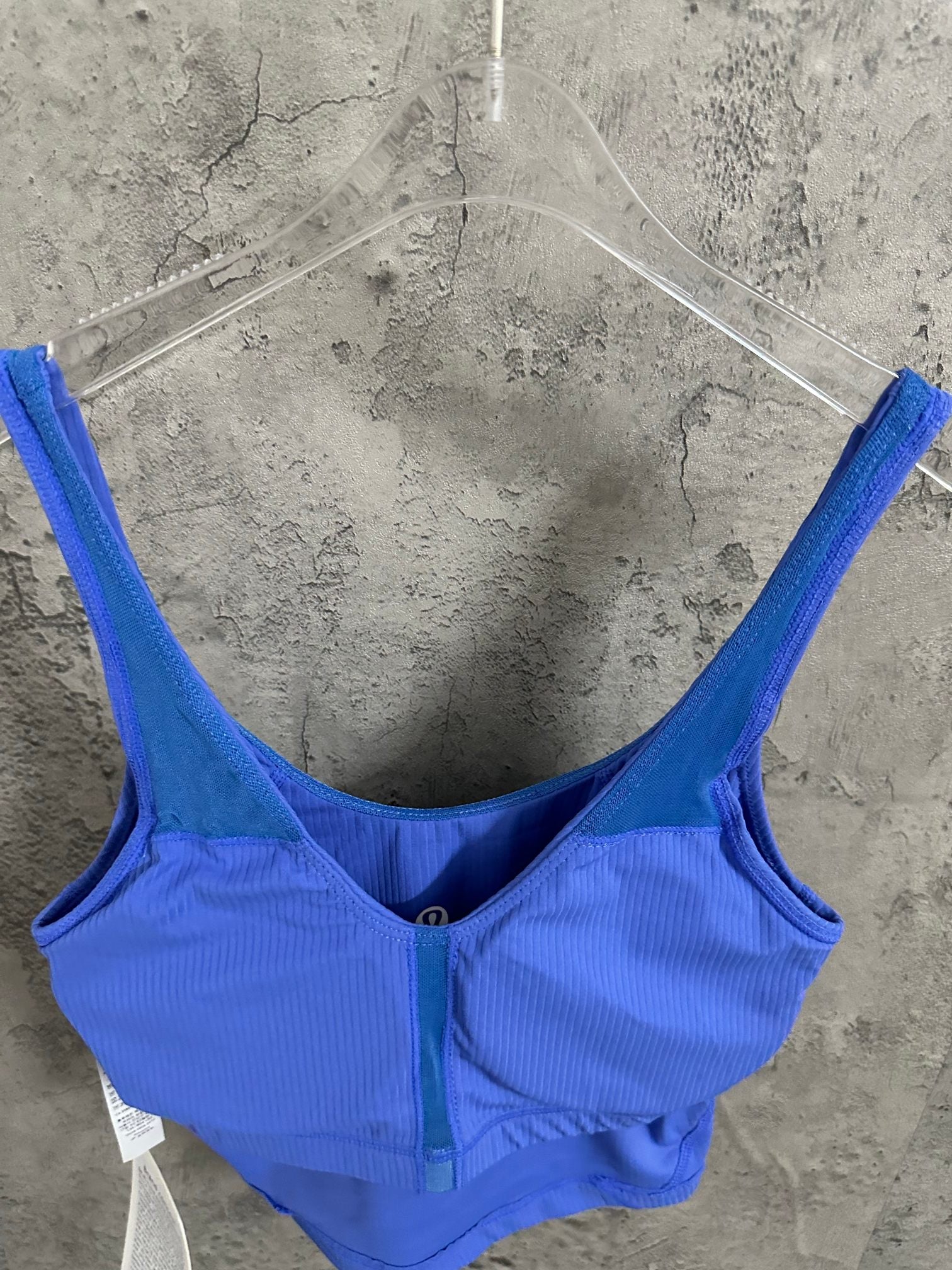 Blue ribbed tank top with scoop back, center seam, and small front logo