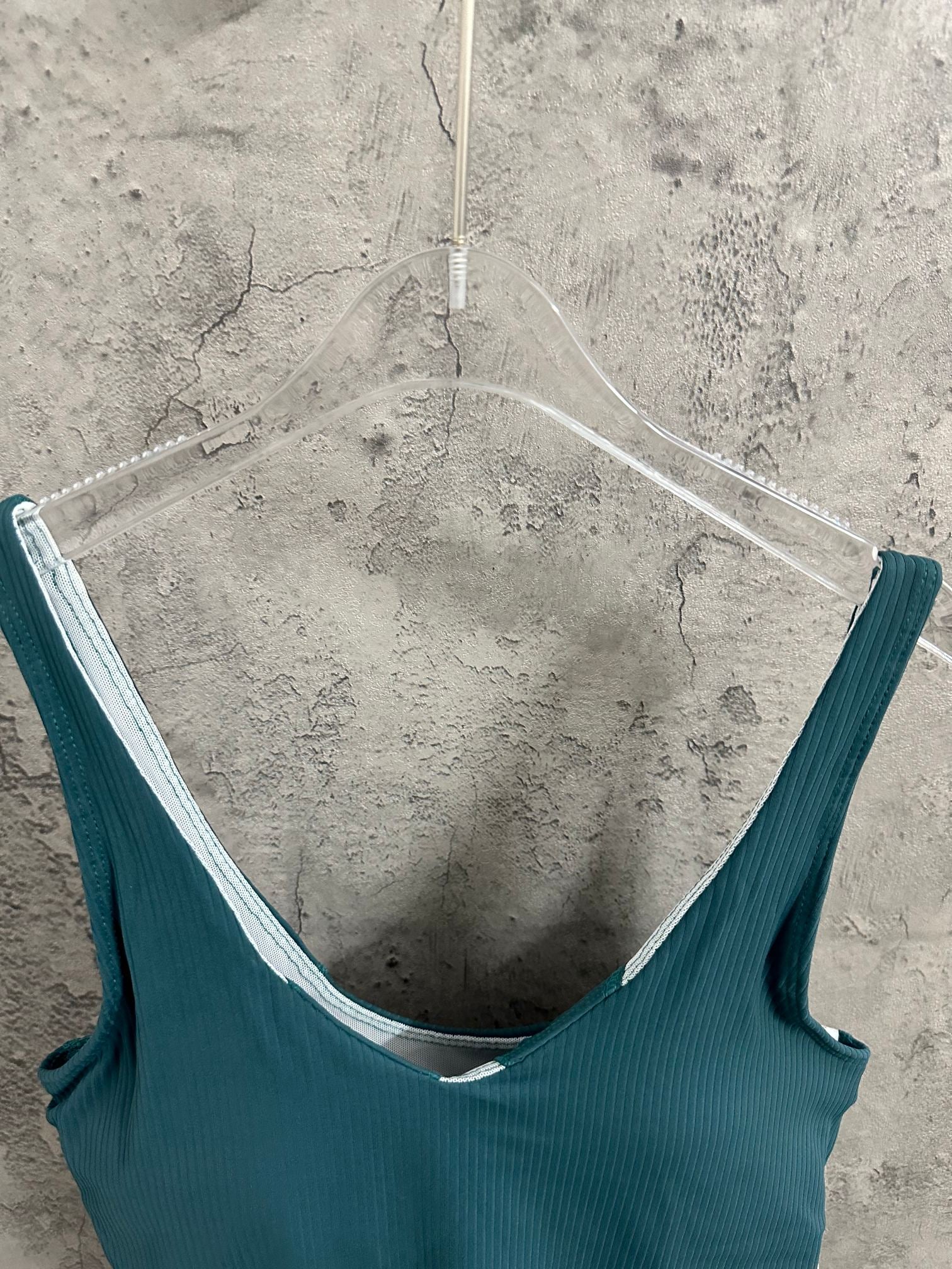 Teal camisole with V back neckline and wide straps; white inner trim