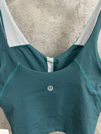 Teal ribbed camisole with scoop neckline and white-trimmed armholes; small logo