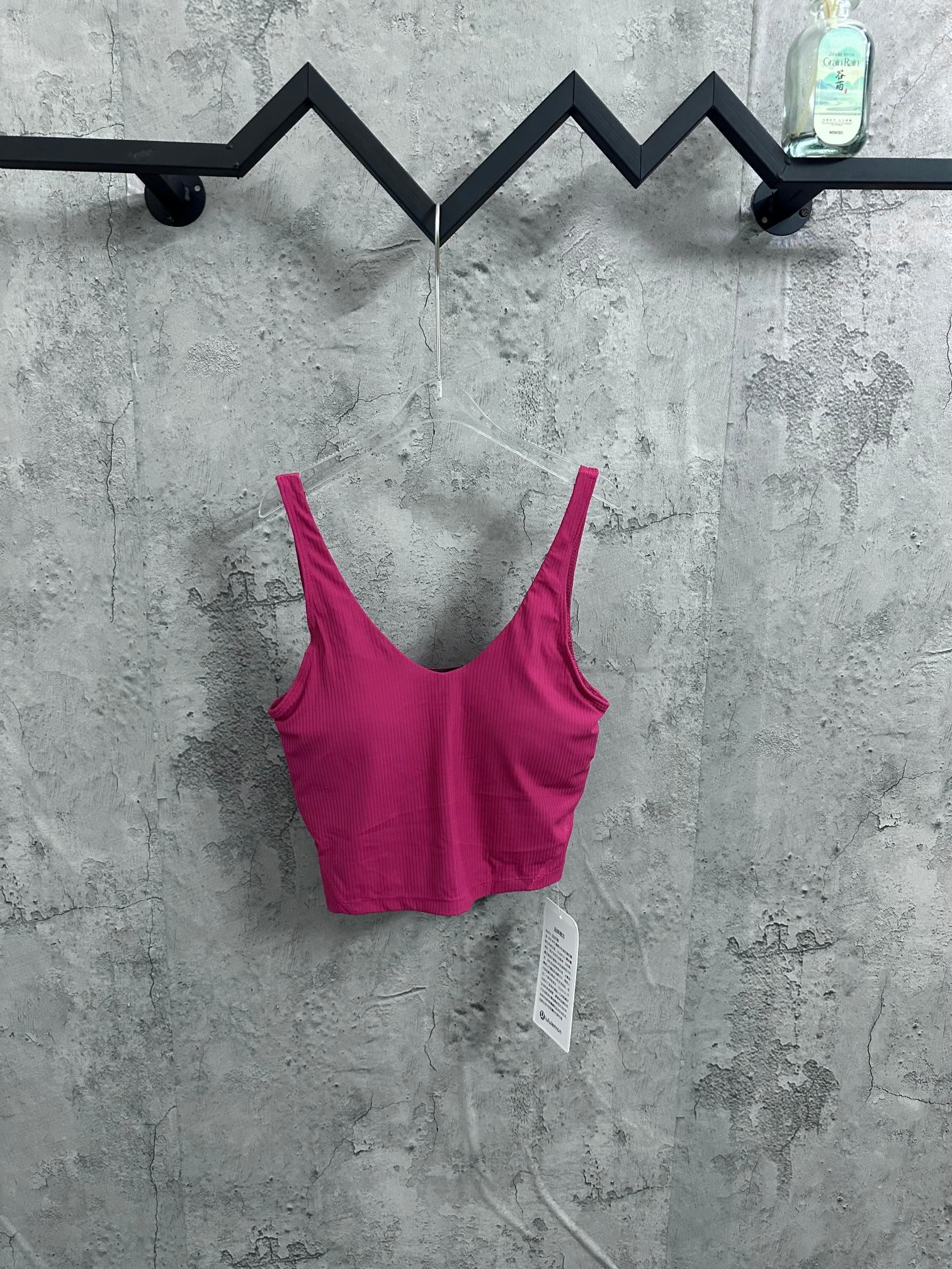 Pink ribbed camisole with spaghetti straps and scoop neck, black trim