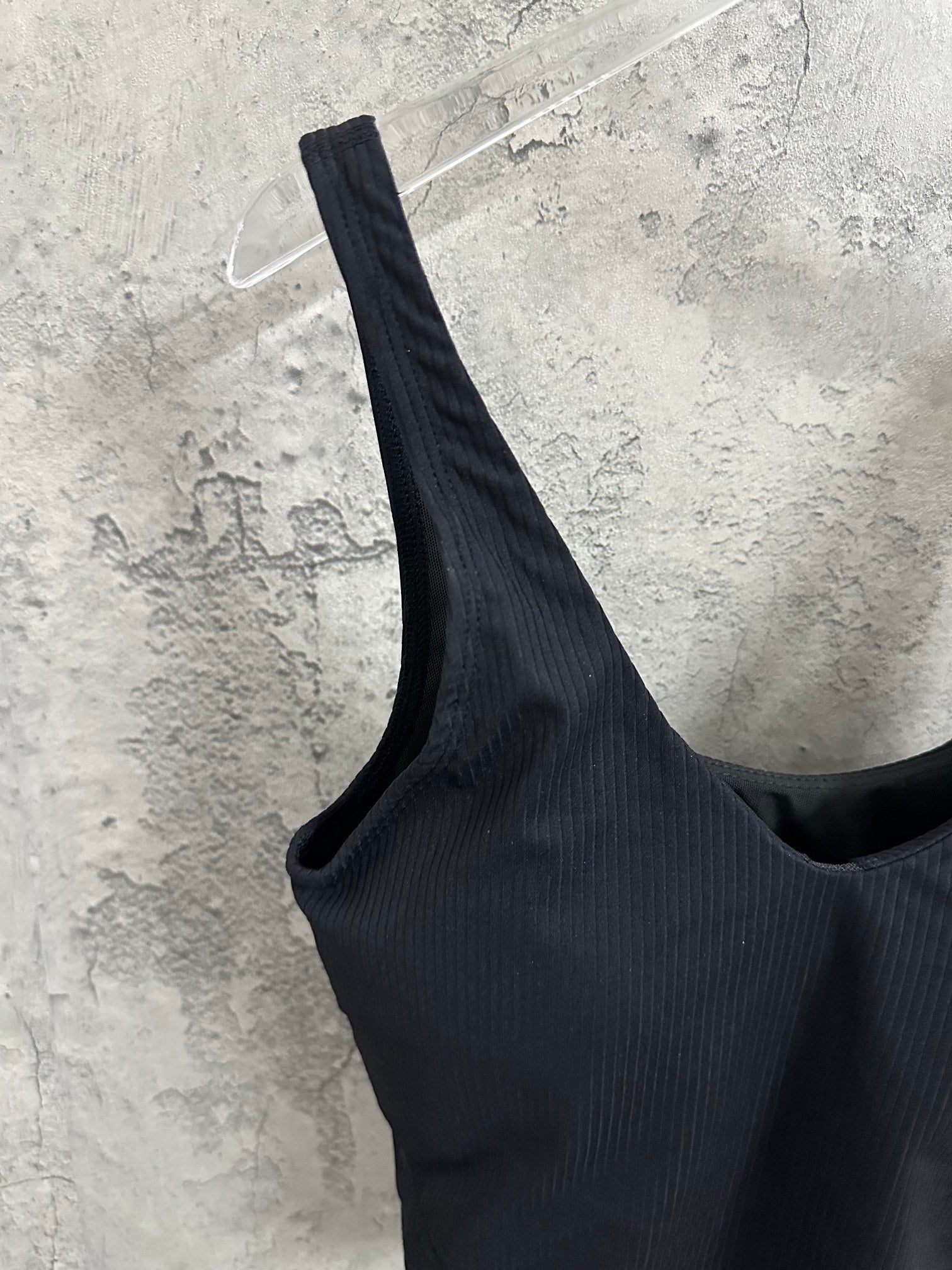 Black ribbed sports bra angled view showing wide strap and neckline