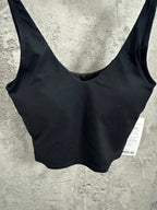 Black ribbed sports bra close-up of scoop neckline and shoulder straps