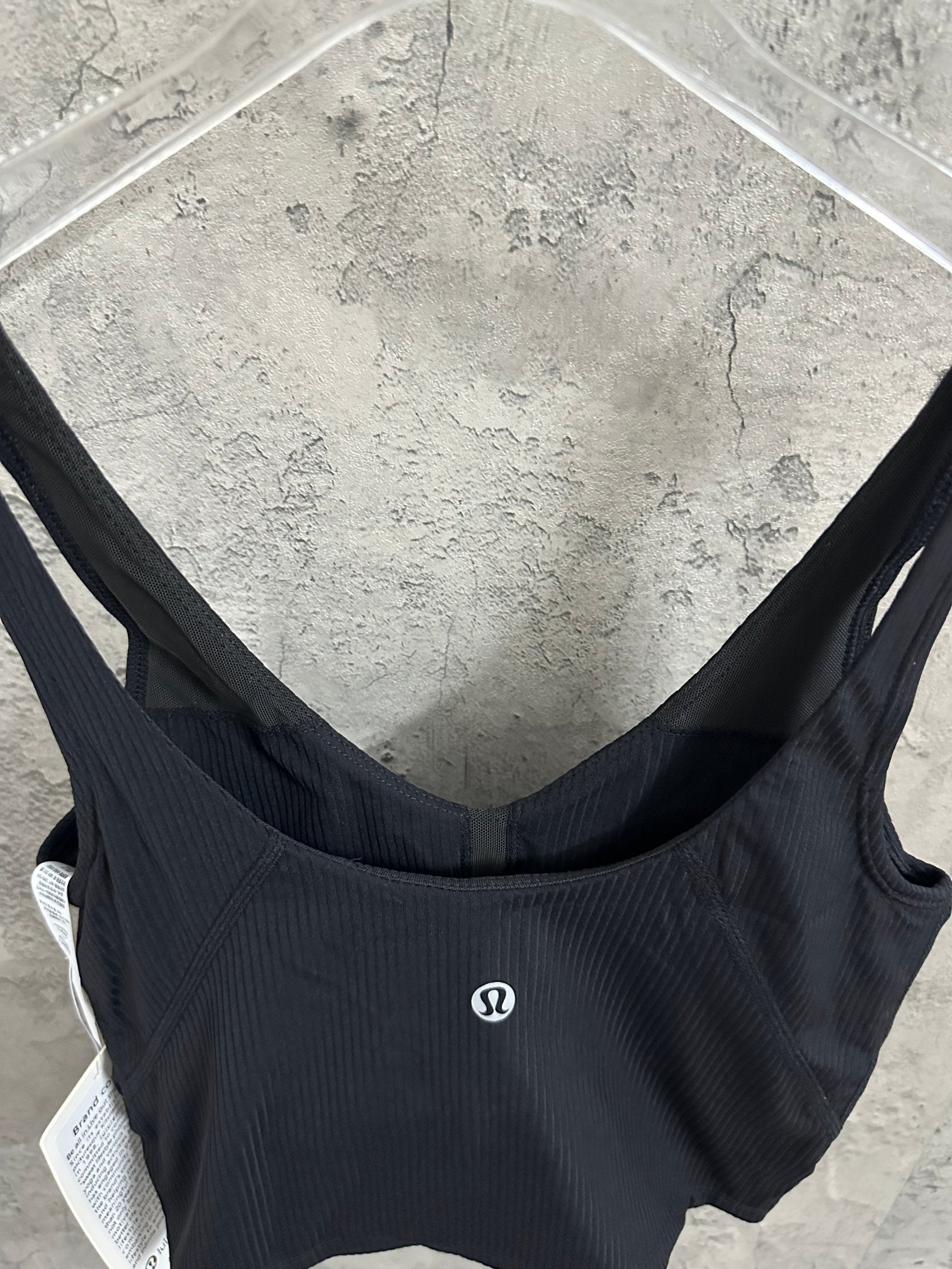 Black ribbed sports bra back view with small chest logo patch
