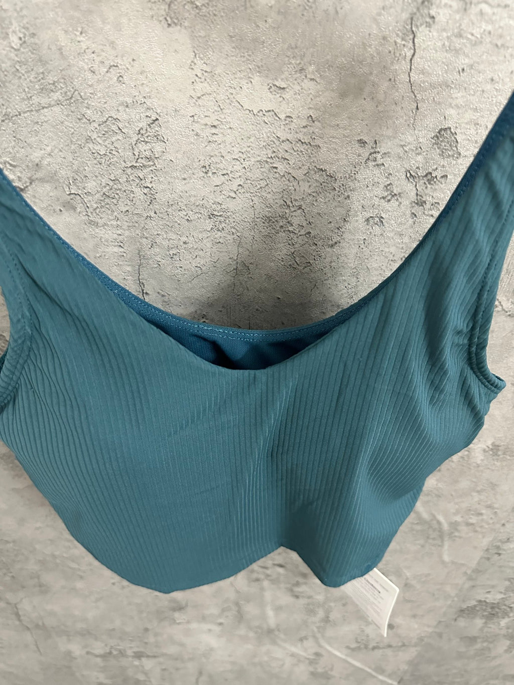 Teal ribbed tank top detail with curved scoop neckline and wide straps