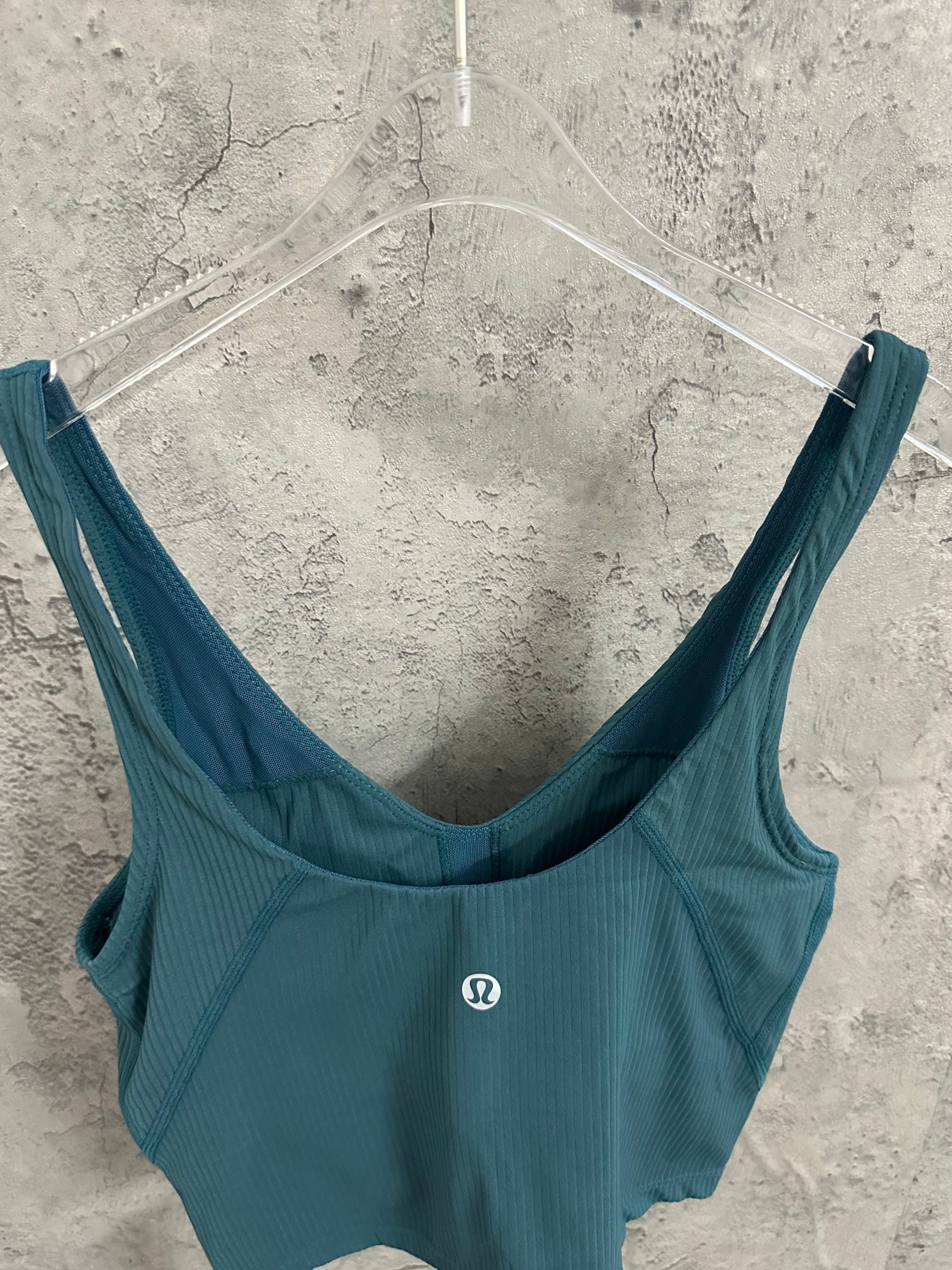 Teal ribbed bra-style tank top with wide straps and small front logo