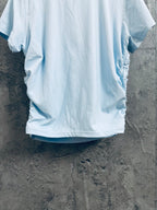 Light blue short-sleeve T-shirt with ribbed texture, shown from back on hanger