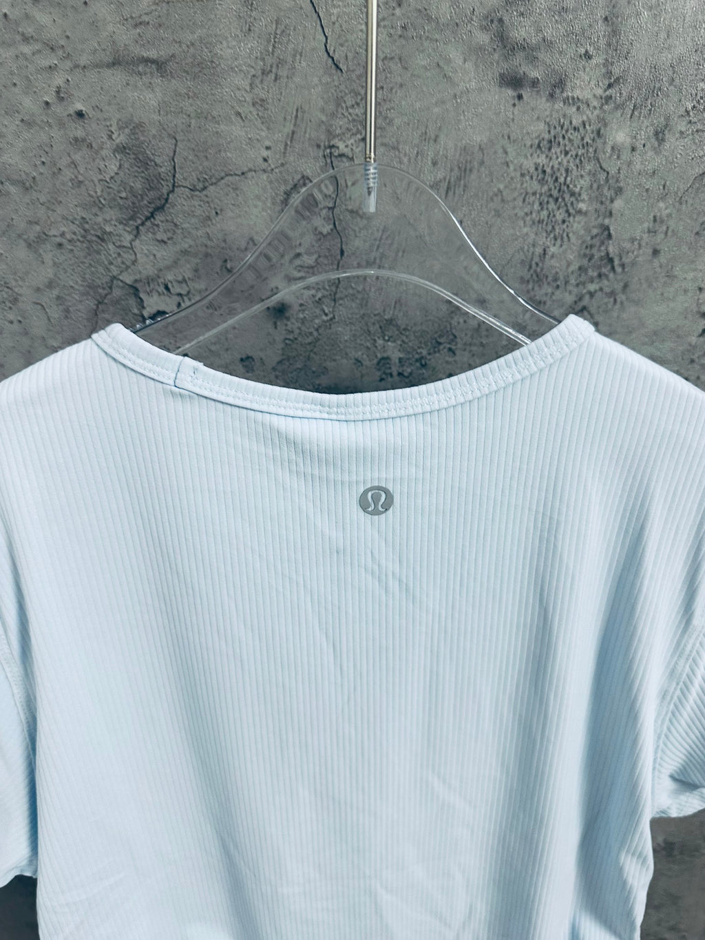 Light blue T-shirt back view with small round logo at upper back